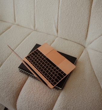 rose-gold-laptop-sits-on-fluffy-sofa