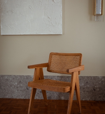 artistic-chair-sits-empty-next-to-large-wall-painting
